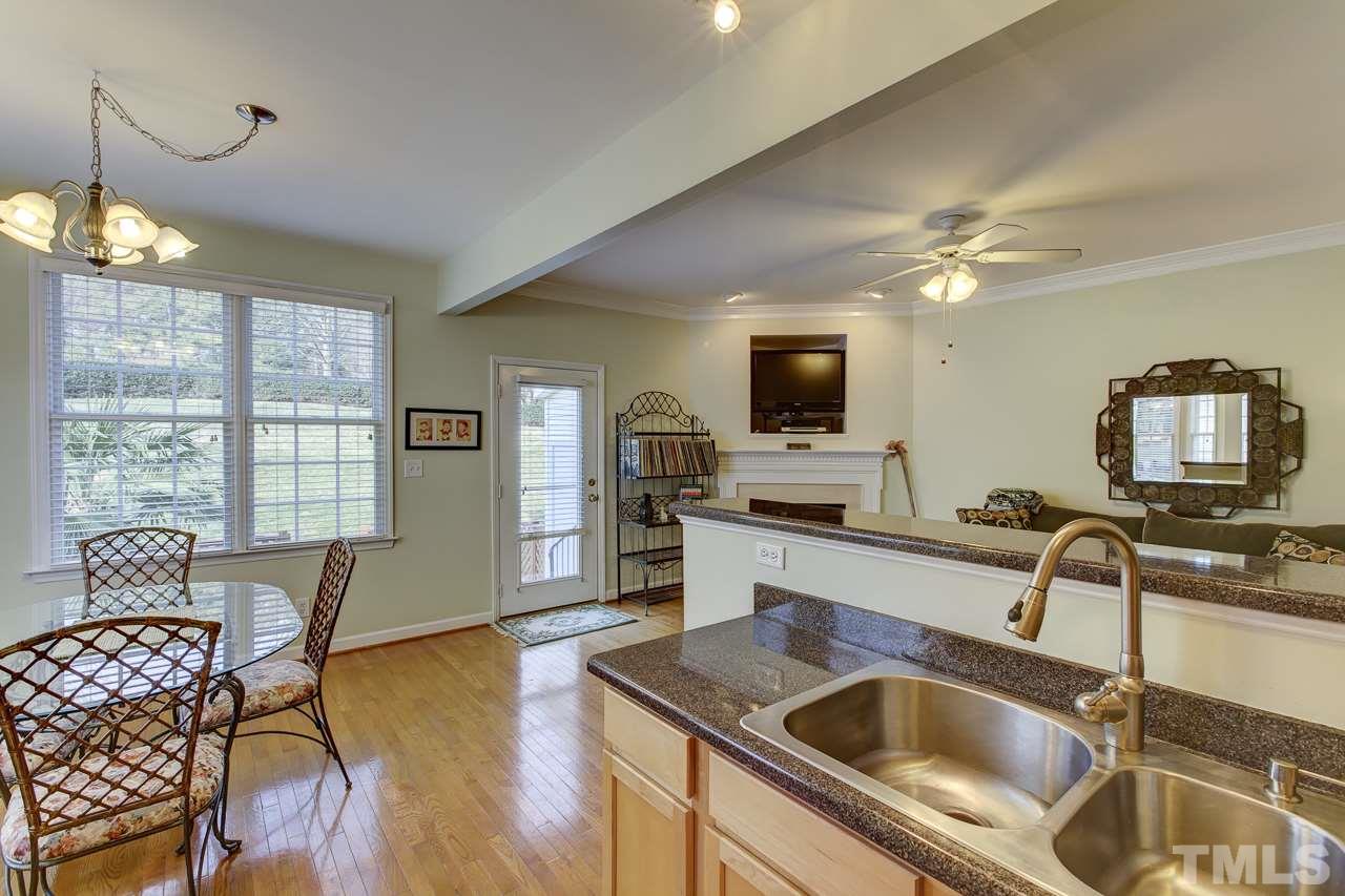5410 Goldenglow Way Raleigh, NC 27606 - Photo 13 of 24 a kitchen with a sink a counter space dining table and chairs