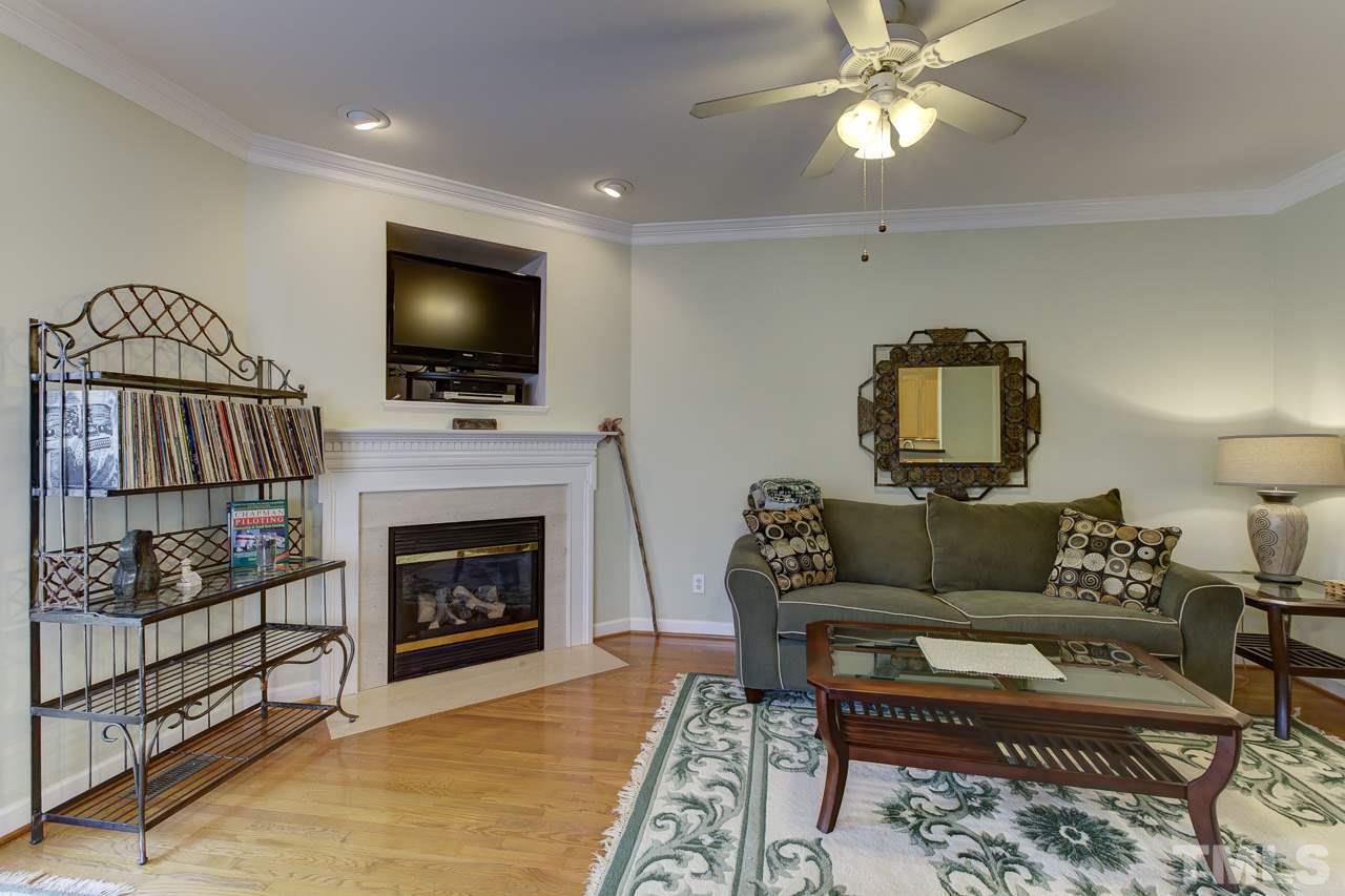 5410 Goldenglow Way Raleigh, NC 27606 - Photo 5 of 24 a living room with furniture a flat screen tv and a fireplace