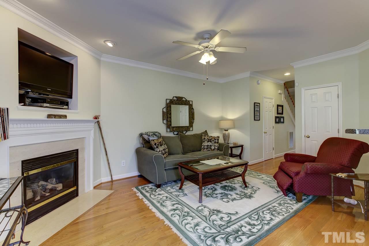 5410 Goldenglow Way Raleigh, NC 27606 - Photo 6 of 24 a living room with furniture a flat screen tv and a fireplace