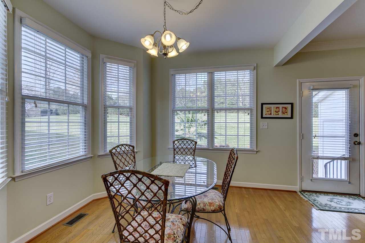 5410 Goldenglow Way Raleigh, NC 27606 - Photo 10 of 24 a dining room with furniture a chandelier and wooden floor