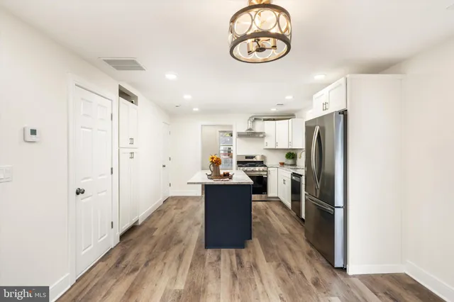 a kitchen with a refrigerator and a stove top oven