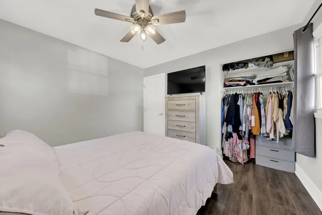a bedroom with a large bed and a flat tv screen