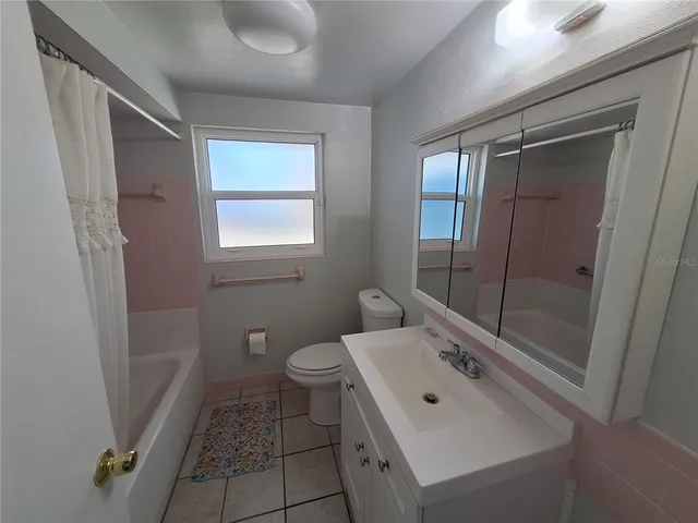 a bathroom with a sink mirror vanity and toilet