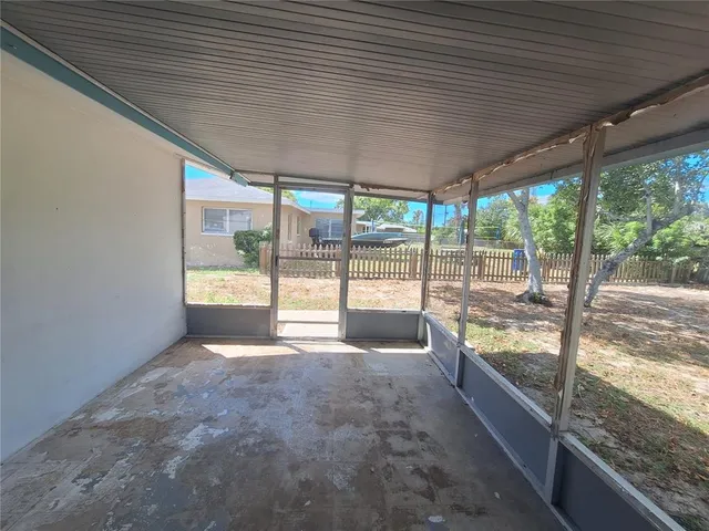 a view of an empty room with wooden floor and iron stairs