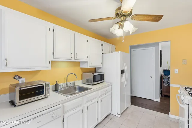 a kitchen with stainless steel appliances a sink a refrigerator and cabinets