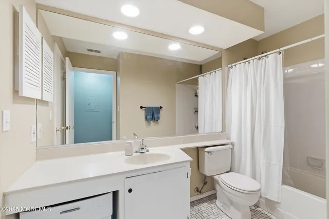 a bathroom with a double vanity sink toilet and a mirror