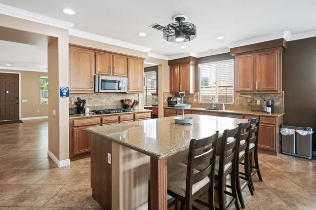 a kitchen with stainless steel appliances granite countertop a stove a sink a microwave and a refrigerator