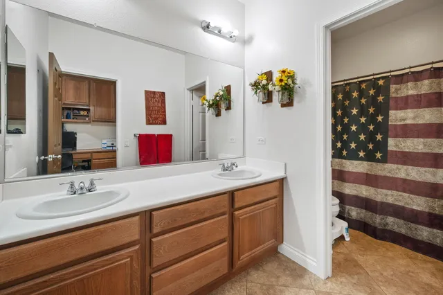 a bathroom with a sink double vanity granite and a shower