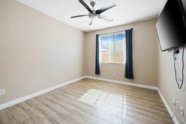 a view of an empty room with a window and a flat screen tv