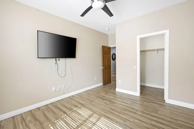 a view of a livingroom with wooden floor and a ceiling fan