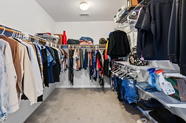 a view of walk in closet with clothes and shoes
