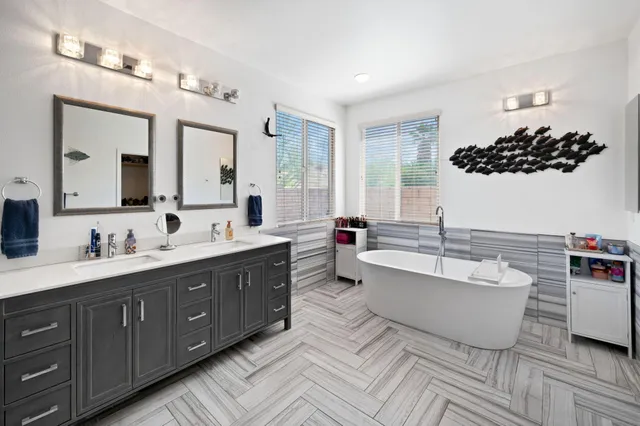 a spacious bathroom with a double vanity sink mirror and bathtub