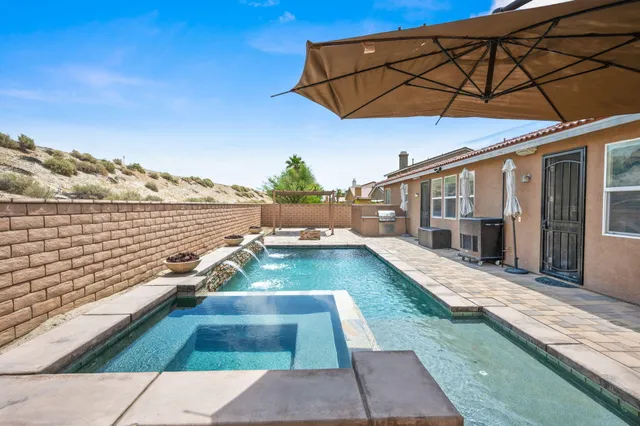 a view of a patio with lawn chairs under an umbrella