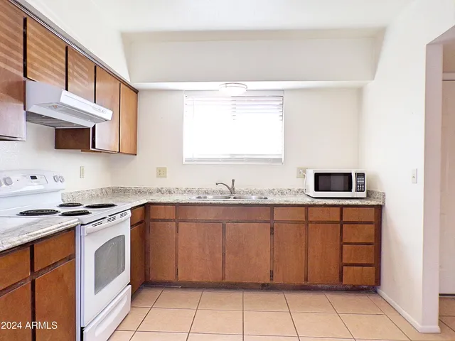 a kitchen with stainless steel appliances granite countertop a refrigerator sink and stove
