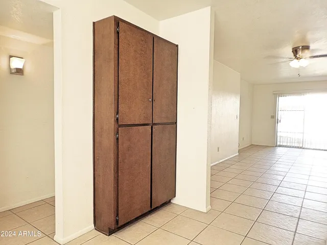 an empty room with windows and fan