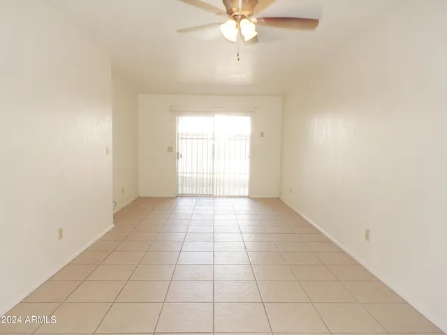 a view of an empty room and window chandelier fan