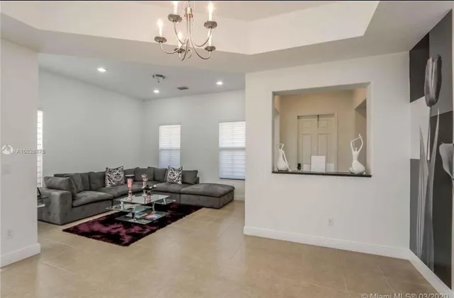 a living room with furniture and a chandelier