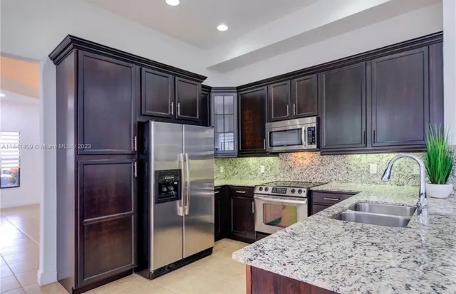 a kitchen with stainless steel appliances granite countertop a stove and a sink