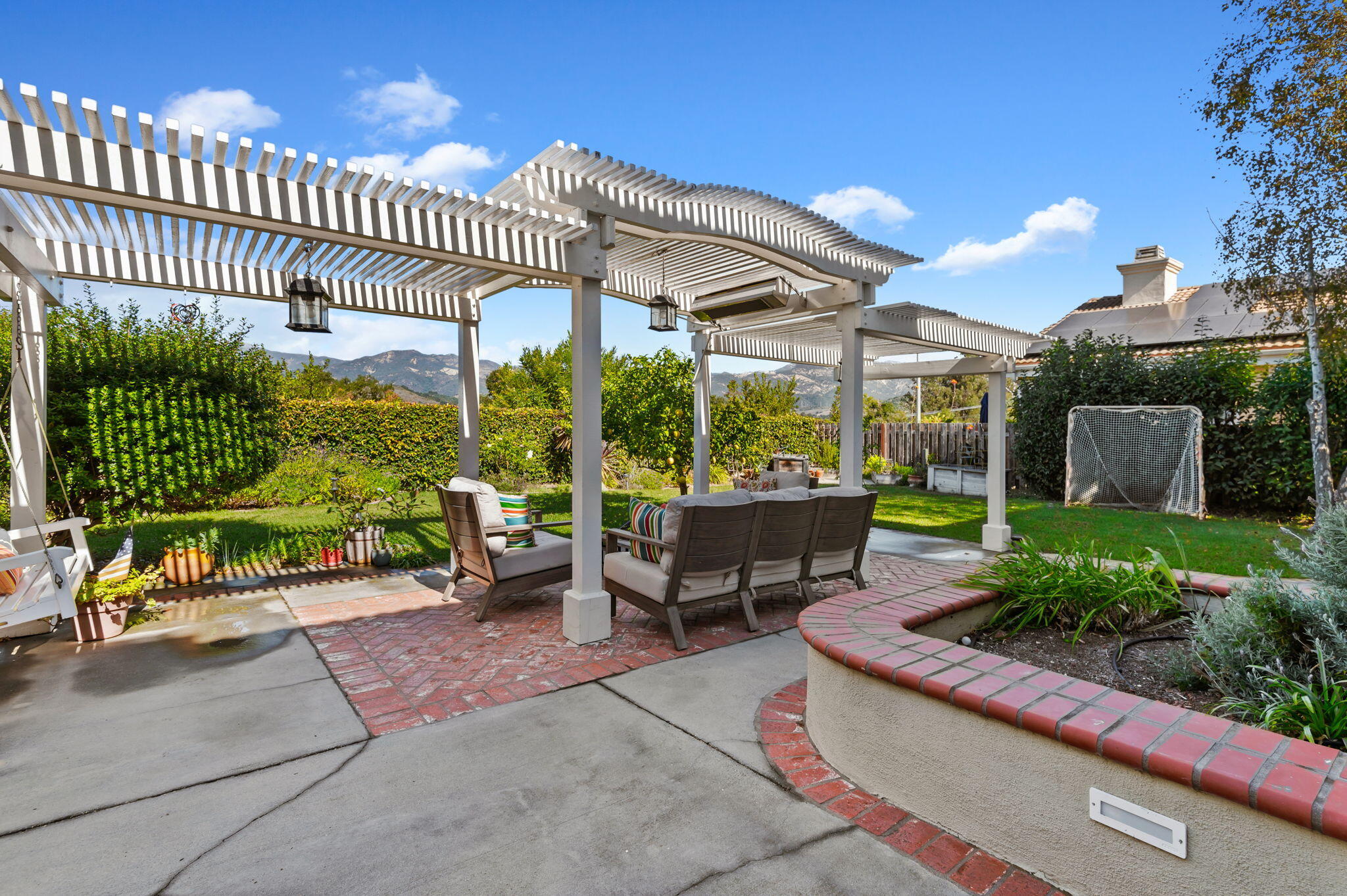 7818 Day Road Goleta, CA 93117 - Photo 17 of 24 a view of a patio with couches table and chairs potted plants with wooden floor and fence