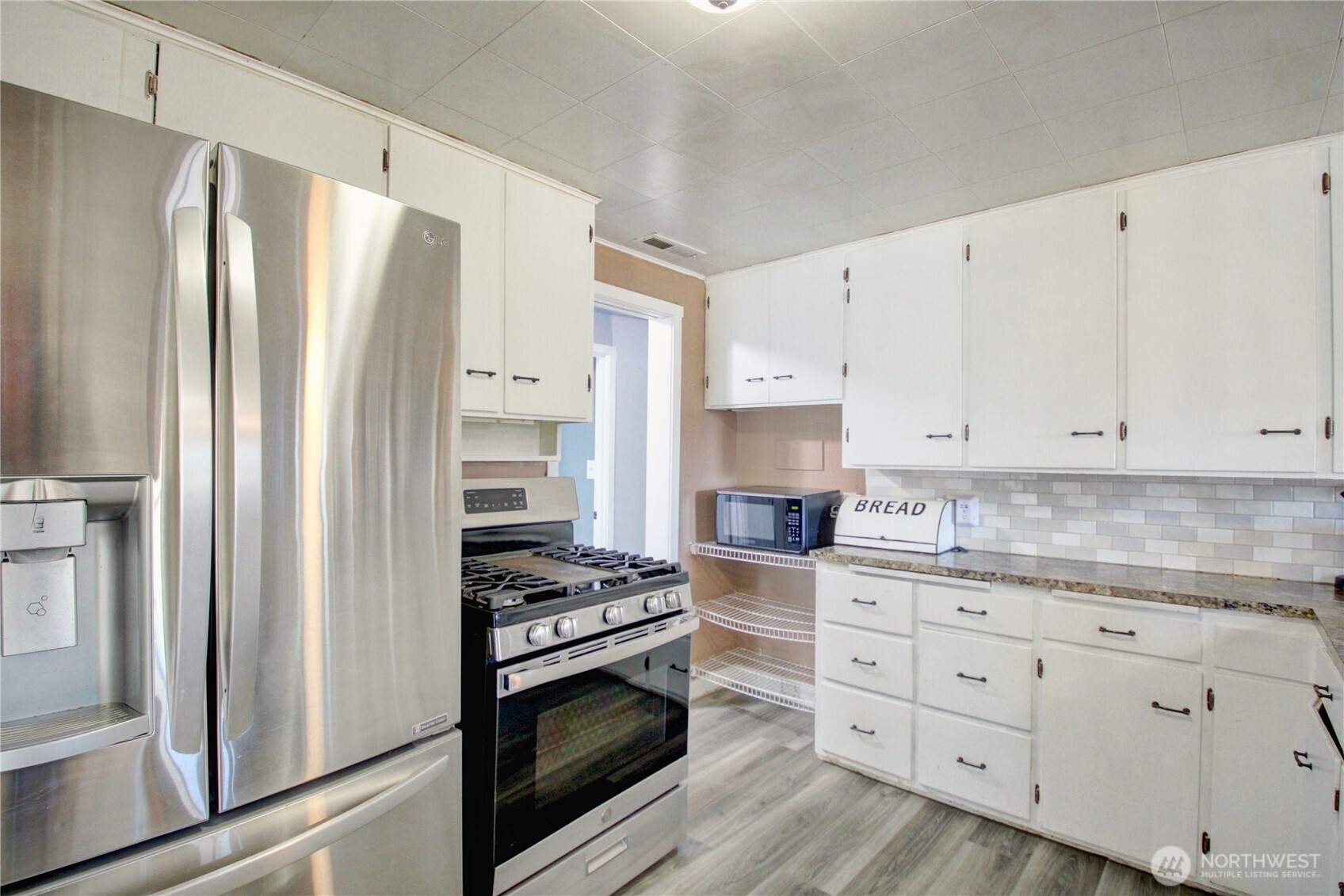 16027 West Division Street Mount Vernon, WA 98273 - Photo 11 of 36 a kitchen with stainless steel appliances a stove a refrigerator and cabinets
