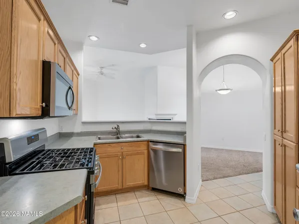 a kitchen with granite countertop a sink cabinets and stainless steel appliances