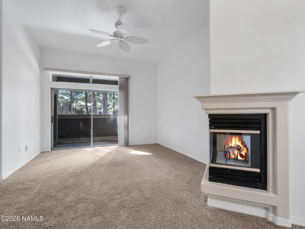 an empty room with a fireplace and windows