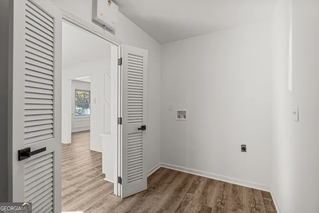 a view of a hallway with wooden floor and closet