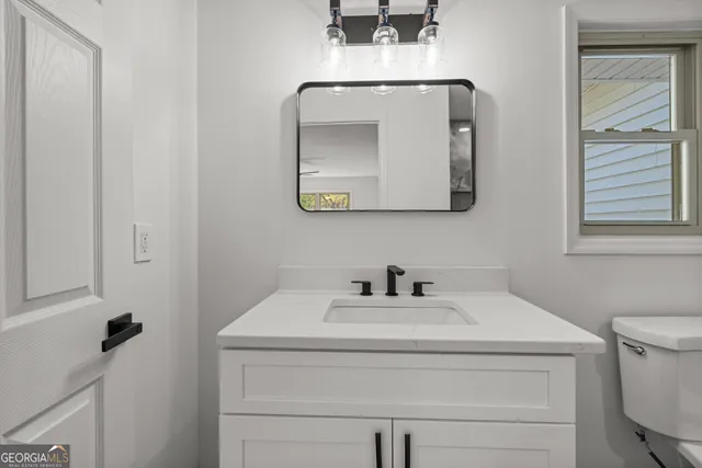 a bathroom with a toilet sink and mirror