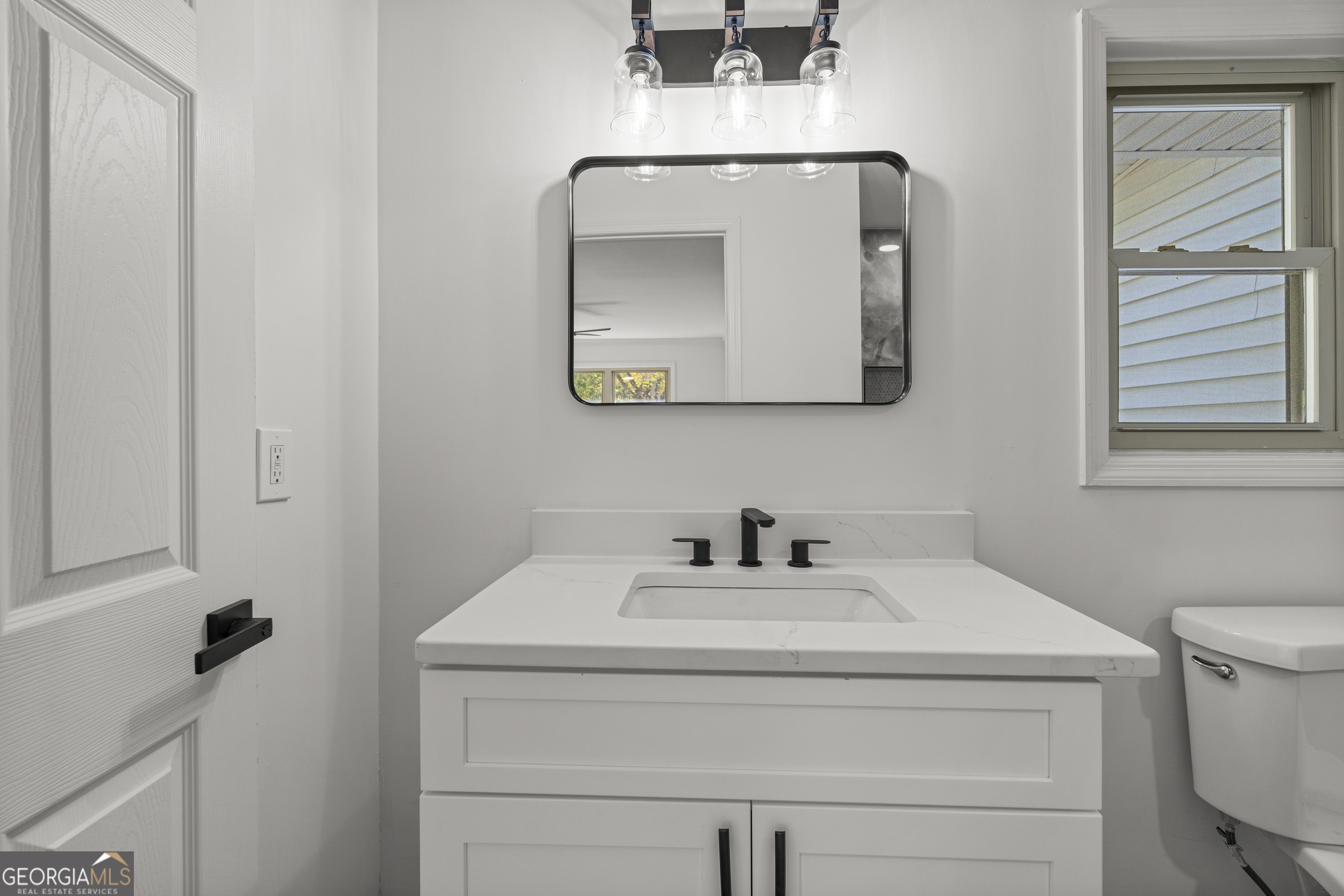 4903 Chapman Street Columbus, GA 31907 - Photo 15 of 19 a bathroom with a toilet sink and mirror