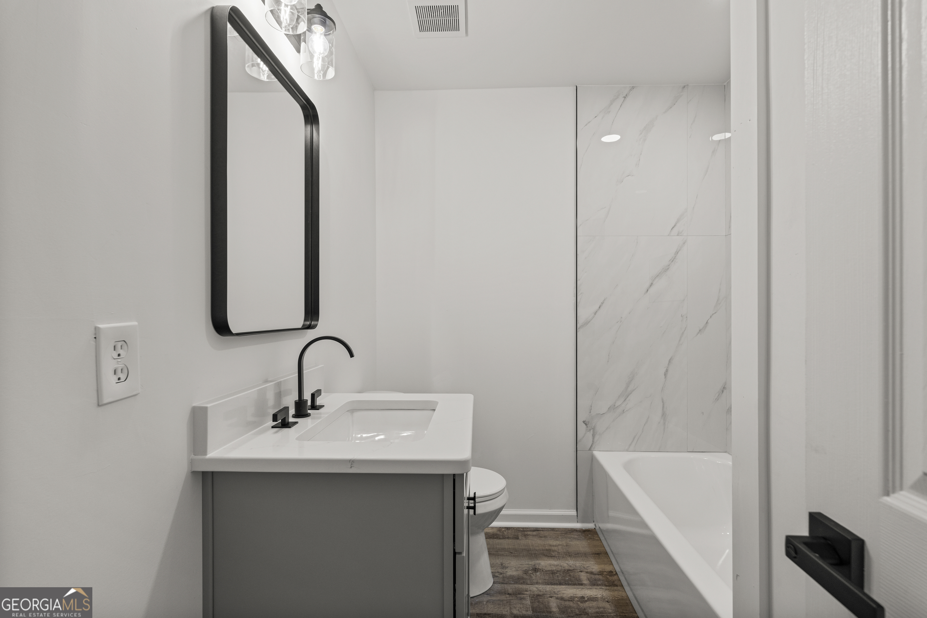 4903 Chapman Street Columbus, GA 31907 - Photo 18 of 19 a bathroom with a sink and mirror with bathtub