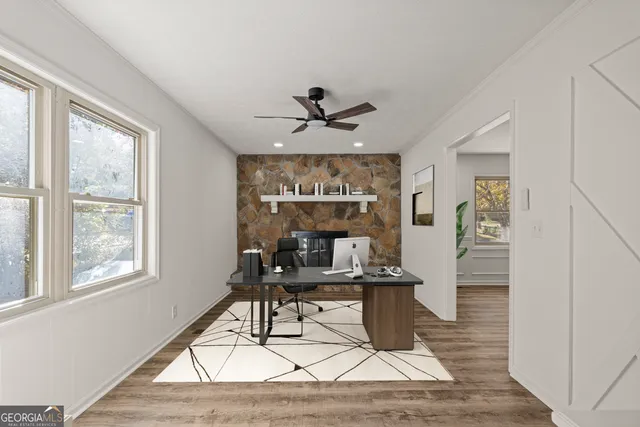 a workspace with wooden floor and a chandelier fan