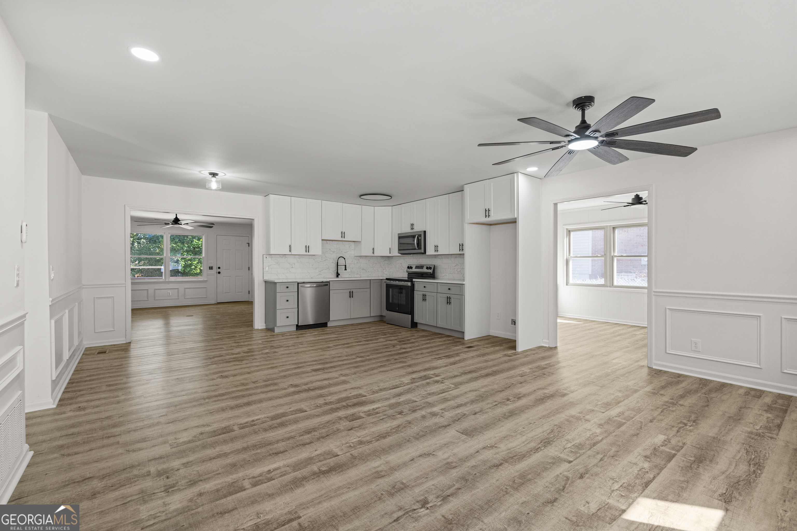 4903 Chapman Street Columbus, GA 31907 - Photo 4 of 19 a view of an empty room with a kitchen and wooden floor