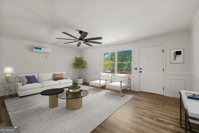 a living room with furniture wooden floor and a window