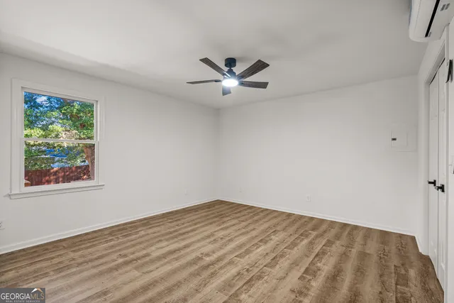 an empty room with a window and a ceiling fan