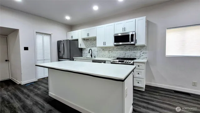 a kitchen with stainless steel appliances microwave stove refrigerator and microwave