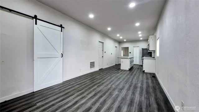 a view of empty room with wooden floor