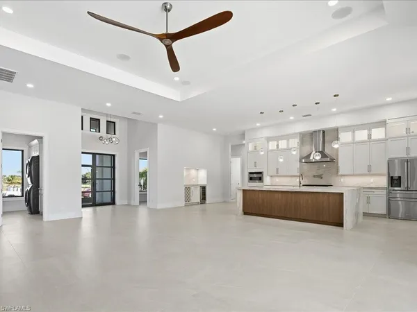 a large kitchen with stainless steel appliances granite countertop a lot of cabinets and wooden floor