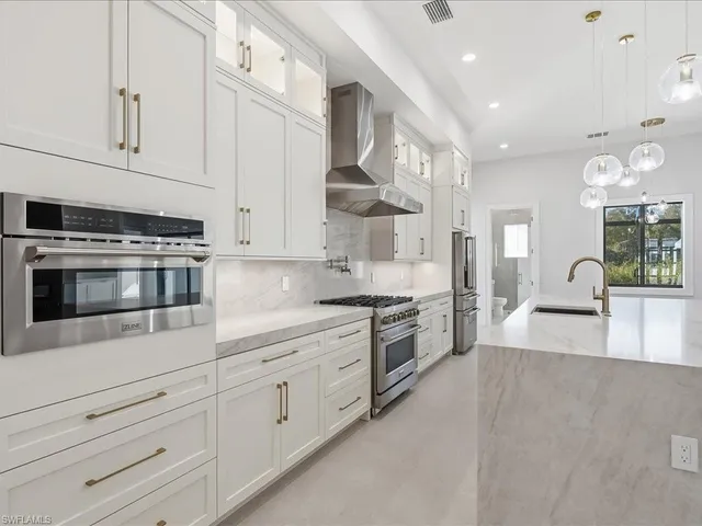 a kitchen with stainless steel appliances a refrigerator sink and cabinets