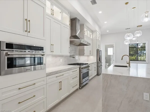 a kitchen with stainless steel appliances a refrigerator sink and cabinets