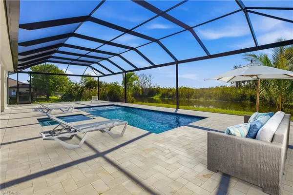 a view of backyard with swimming pool and sitting area