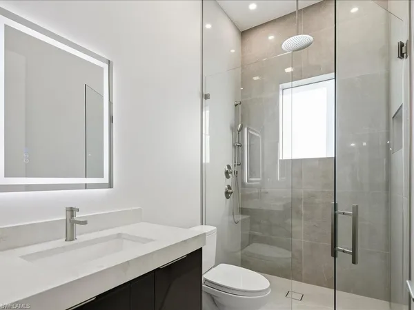 a bathroom with a sink a toilet and shower