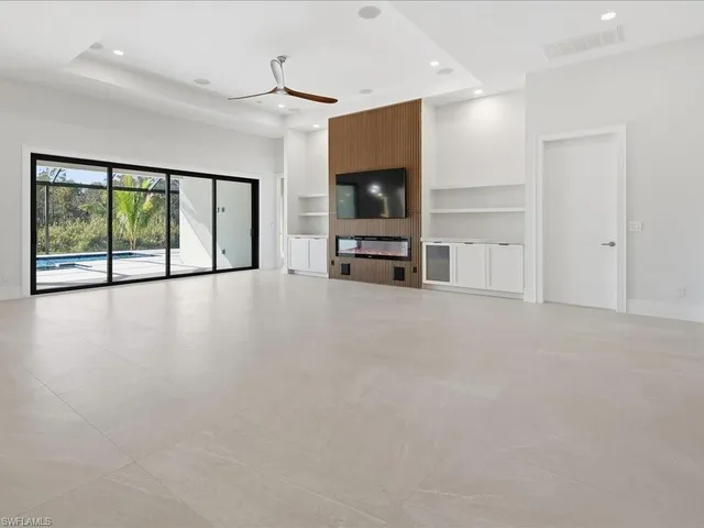 a view of a livingroom with furniture flat screen tv and floor to ceiling window