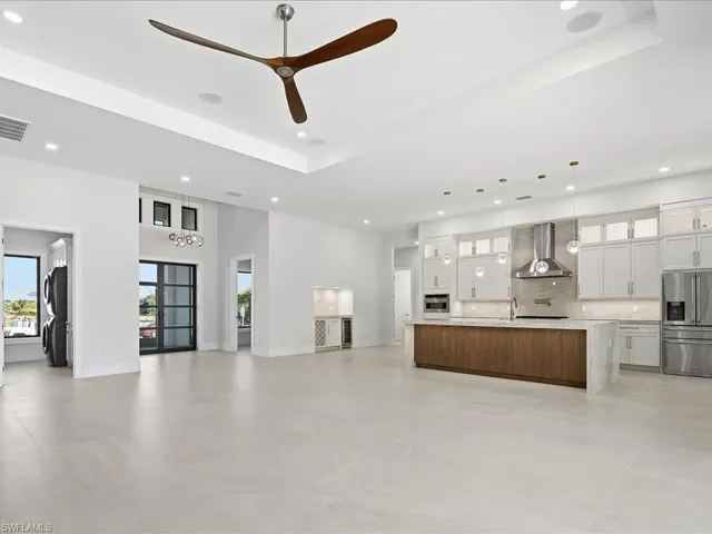 a large kitchen with stainless steel appliances granite countertop a lot of cabinets and wooden floor