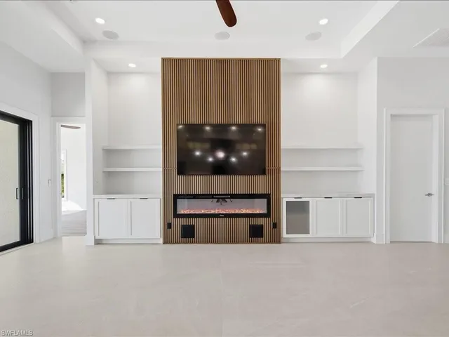 an empty room with kitchen and a fireplace