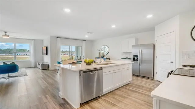 a kitchen with sink stove and refrigerator