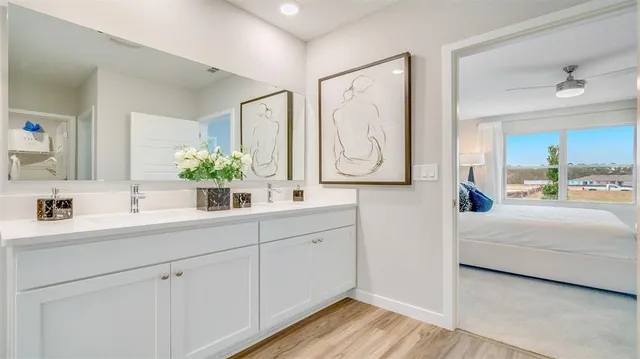 a en suite bathroom with 2 sink flowerpot and a mirror