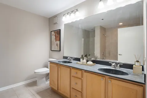 a bathroom with a granite countertop sink mirror and toilet