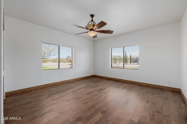 a view of an empty room with window and wooden floor