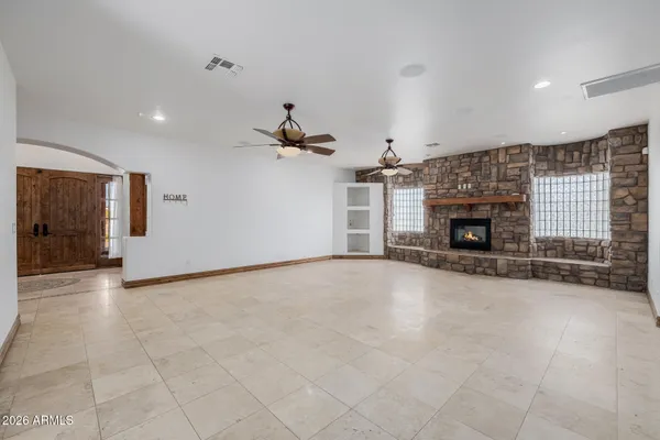 an empty room with windows and fireplace