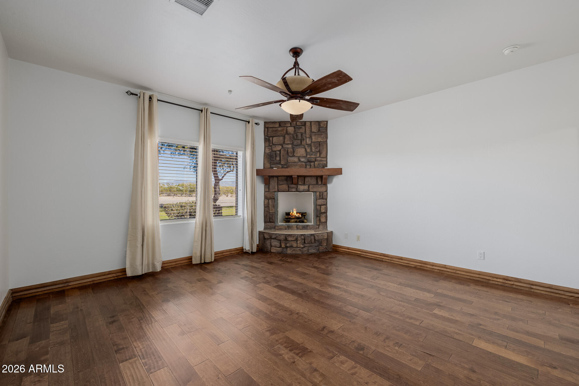 1815 West Maddock Road Phoenix, AZ 85086 - Photo 31 of 71 a view of a livingroom with wooden floor a ceiling fan and a window